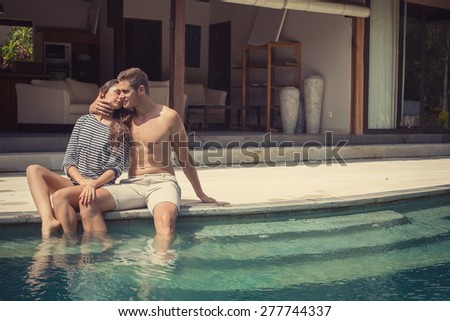 Young love fashion couple near swimming pool at the luxury villa on vacation