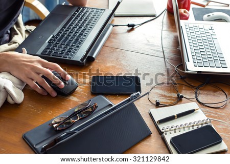 Freelance work space, notebooks, tablet, smartphone, note paper, pen. Job and study online. Man sitting at laptop, Working and typing