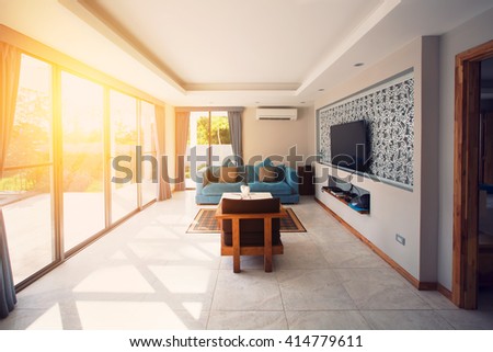 Villa interior living room. Sunlight through big window, terrace