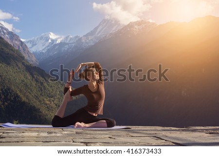 Morning Exercises in mountains landscape. Young Woman doing Yoga outdoor