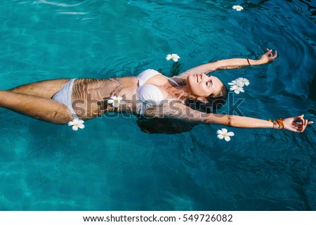 Beautiful female in swimming pool background with white Spa flowers