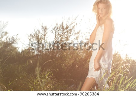 Young girl on a green field during early morning sunrise