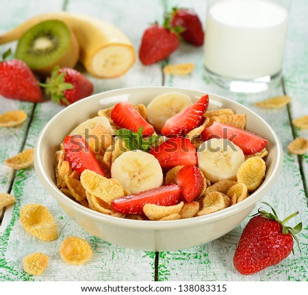 Cornflakes with fruits on a white table