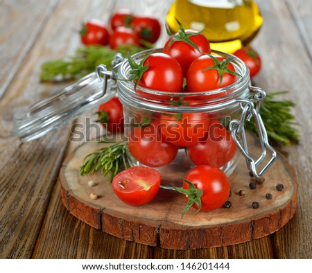 Cherry tomatoes in a glass jar on a brown table