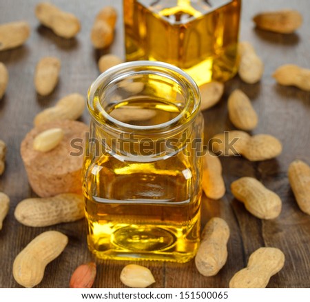 Peanut oil in a glass bottle on a brown background
