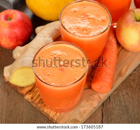 Fresh apple and carrot juice on brown background