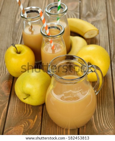Smoothie of banana and apple on a brown background