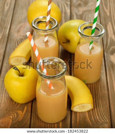 Smoothie of banana and apple on a brown background