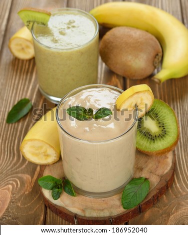 Smoothies of banana and kiwi on a brown background