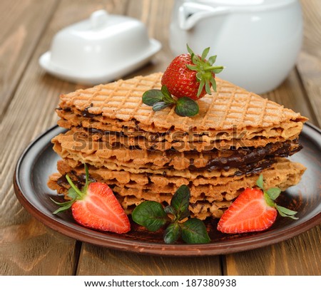 Waffles with strawberries on brown background