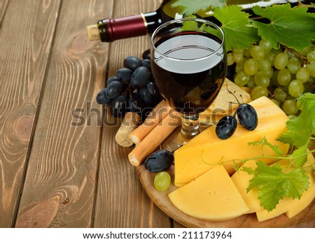 Wine, grapes and cheese on brown background