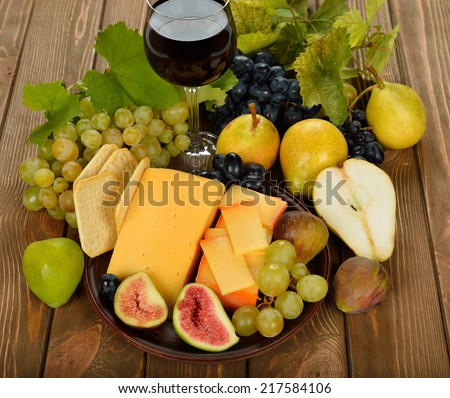 Cheese and fruit on a brown background