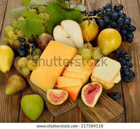 Cheese and fruit on a brown background