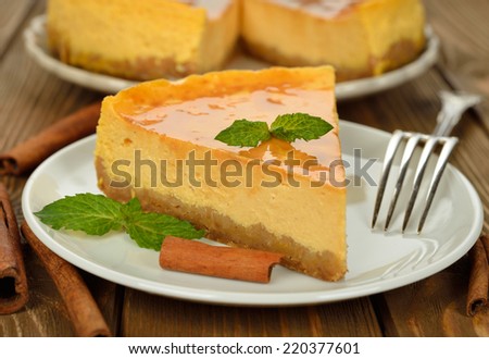 Pumpkin cheesecake with caramel icing on brown background