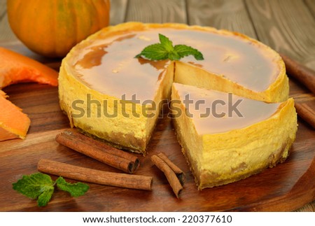 Pumpkin cheesecake with caramel icing on brown background