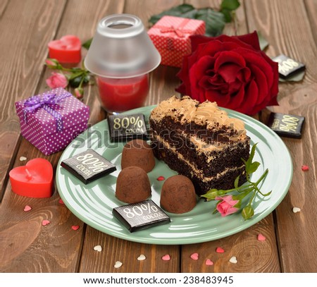 Piece of cake with chocolate truffles on a brown background