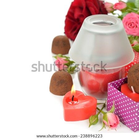 Chocolate truffles, candles and roses on a white background
