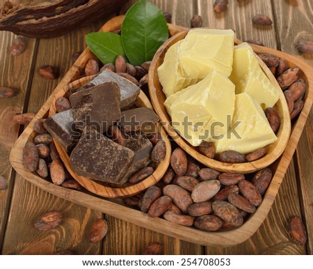 Cocoa beans, cocoa butter and cocoa mass on brown background