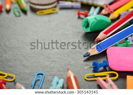 Colorful school supplies on a slate background