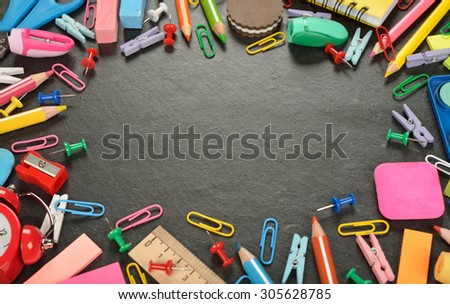 Colorful school supplies on a slate background