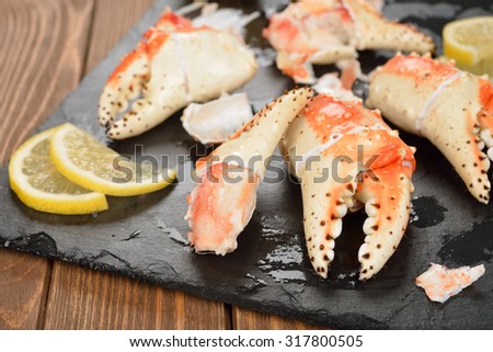 Boiled crab claws with lemon on a black background