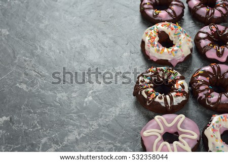 Chocolate donuts with icing on a gray background