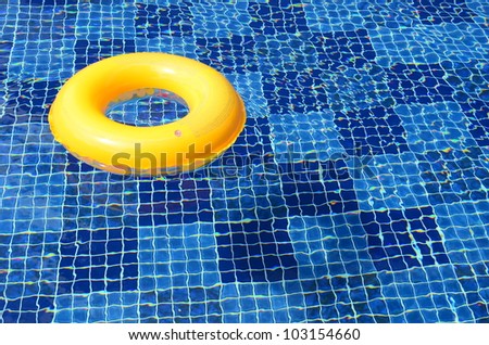 bright yellow swim ring in the deep blue swimming pool