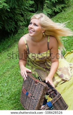 Beautiful young blond woman with picnic crib outdoor