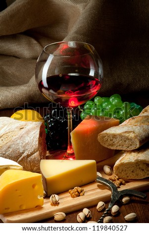 Red wine with cheeses, bread and fruits