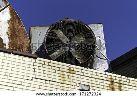 A commercial fan and it\'s components on a roof top.