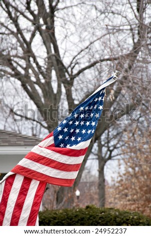 The American flag flying in a city neighborhood against a winter sky.