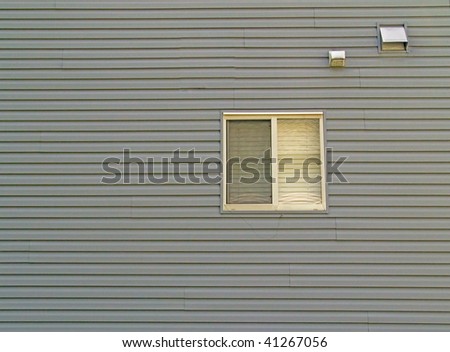 An exterior sided wall with a window.