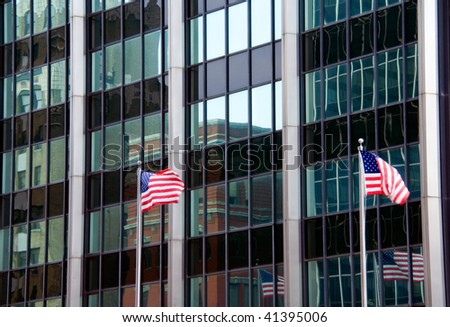 Reflections in an office building with flags also flying and reflected.