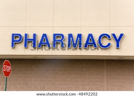 A large blue pharmacy sign on the outside of a building.