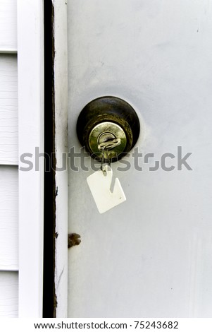 An old door and broken jam with a key in the door knob lock.