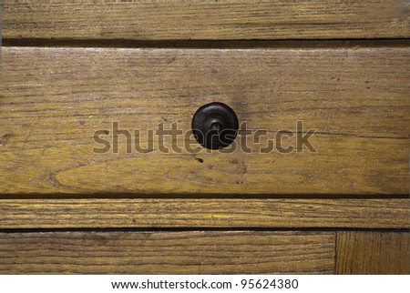An aging wooden drawer with wooden pulls.