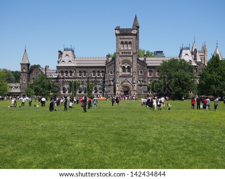 TORONTO - JUNE 12:  Students graduating from the University of Toronto pose for pictures with their families on the lawn in front of University College on June 12, 2013.