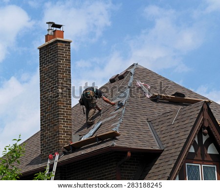 roofer at work repairing a steeply sloped shingle roof