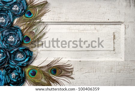 Peacock feathers and flowers on a white antique or vintage door for background