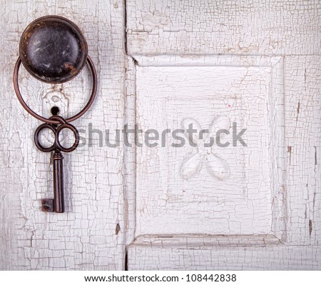 Vintage key hanging on a old cracked antique or vintage door