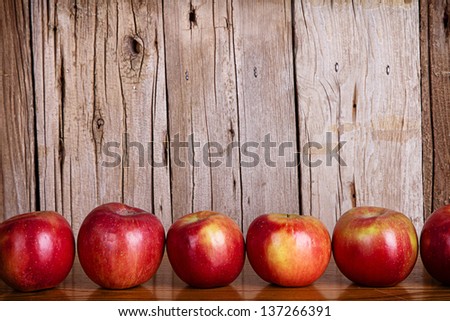 Apples lined up in a row against a white rustic or vintage background