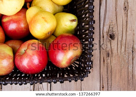 apples and pears in a basket on a wooden basket