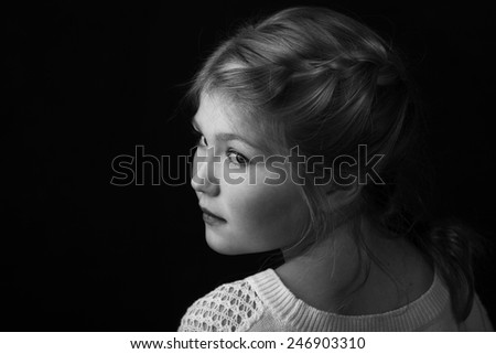 Young girl with braid in hair facing backward with head turned to side.
