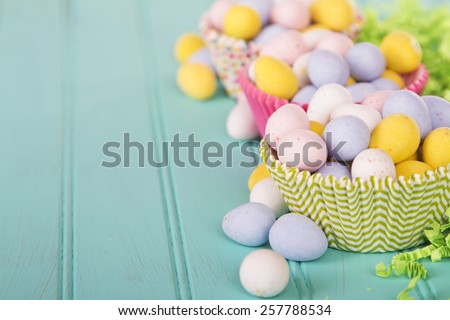 Easter Candy in cup cake wrappers on a turquoise blue wood panel