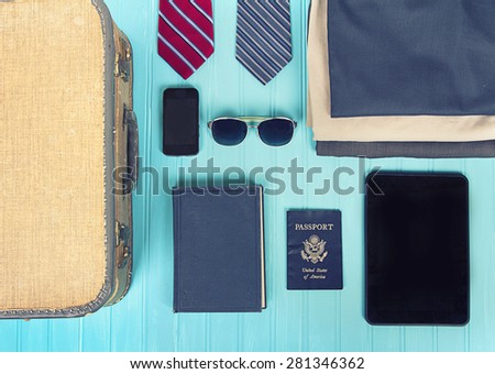 collection of business travel items with a vintage filter on a turquoise background