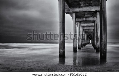 La Jolla beach, California,  long exposure under the pylons, black and white image.