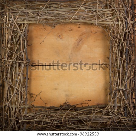 A square grapevine wreath frames a wooden background, room for copy space