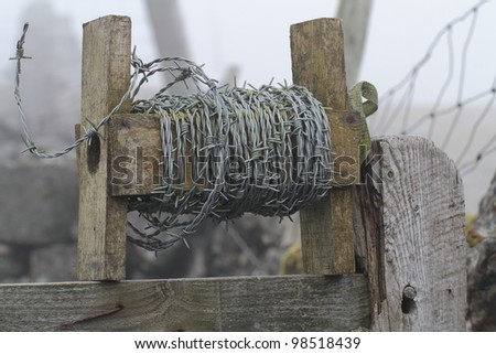 a roll of barbed wire on wooden rack