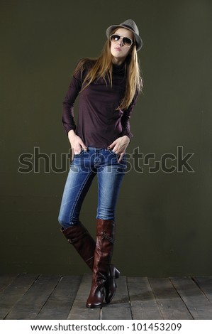 Full length portrait of pretty young woman in sunglasses posing wooden floor