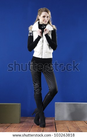 full body fashion woman with cube posing wooden floor on blue background